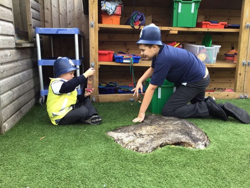 two children kneeling, dressed up as police