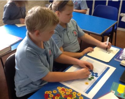 Two children using counters to calculate